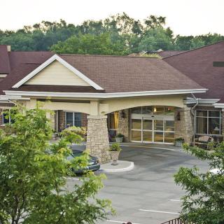 A residential building with a welcoming entrance surrounded by greenery.