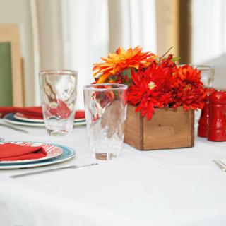 A beautifully arranged dining table featuring vibrant flowers and elegant place settings.
