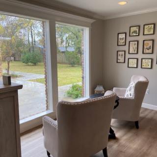 A cozy living room with two chairs facing a large window, offering a pleasant view of the outdoors.