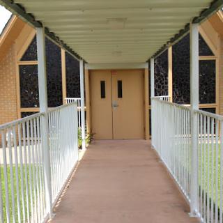 A view of the entrance to a building, featuring a ramp and double doors.