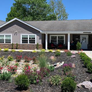 A single-story house with a beautifully landscaped garden in the foreground.