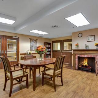 A cozy living room with a table, chairs, and a fireplace.