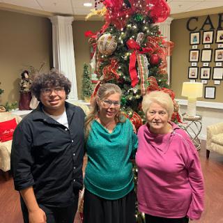A joyful family gathering in front of a beautifully decorated Christmas tree.