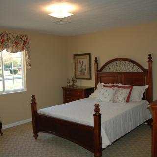 A cozy bedroom with a wooden bed frame and elegant decor.