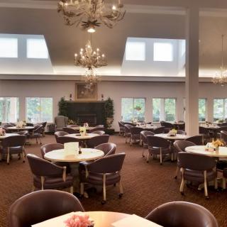 Elegant dining area with round tables and chandeliers.