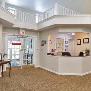 A well-lit office reception area with a desk and carpeted floor.