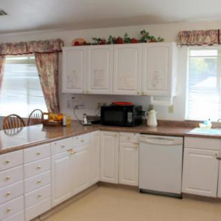 A cozy kitchen with white cabinets and a microwave on the countertop.