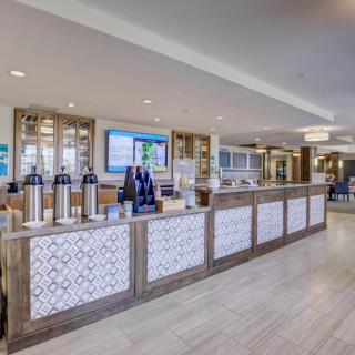 Modern hotel lobby with a welcoming reception desk and coffee station.