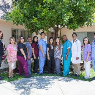 A group of healthcare professionals standing outside in front of a building.