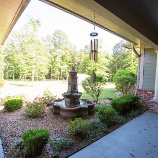 A serene garden view with a decorative fountain surrounded by lush greenery.