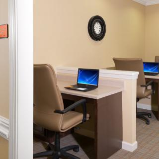 A small office space with desks and laptops set up for work.