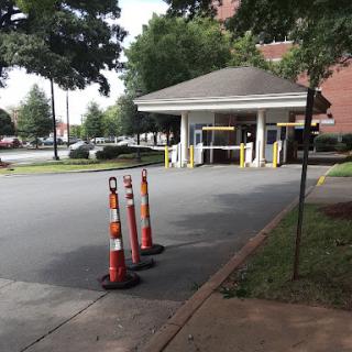 The entrance to a building with traffic cones indicating a lane restriction.