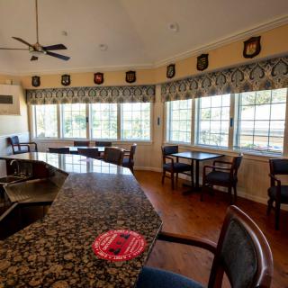 A cozy bar area with large windows and seating arrangements.