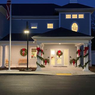A building adorned with holiday decorations and wreaths is illuminated at night.