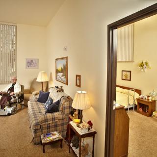 A cozy living space with a connected bedroom, featuring comfortable seating and warm lighting.