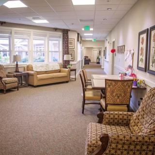 A cozy seating area with sofas and chairs in a well-lit hallway.