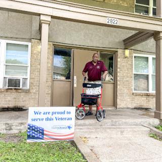 A proud moment in supporting our veterans, as a community member is seen outside their apartment with a mobility aid.