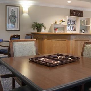 A cozy interior with a table and chairs, adorned with decor and a small cafe area.