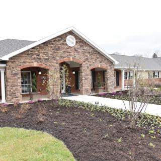 A brick building with a landscaped front yard and walkway.