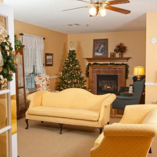 A cozy living room decorated for the holidays with a Christmas tree and fireplace.