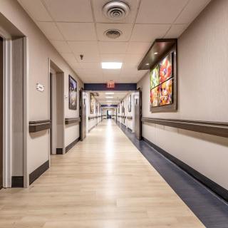 An empty hospital hallway with bright lighting and clean floors.