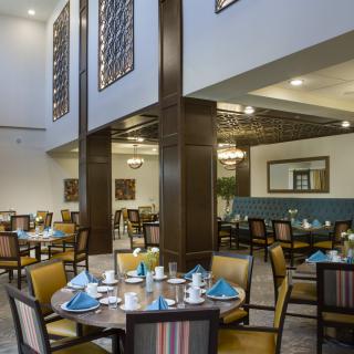 A spacious and elegantly designed restaurant dining area with neatly arranged tables and chairs.