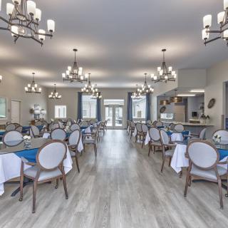 Spacious dining area with elegant chandeliers and neatly arranged tables.