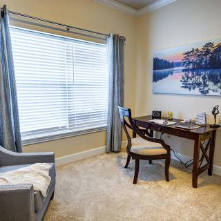 A cozy home office with a desk and chair by the window.