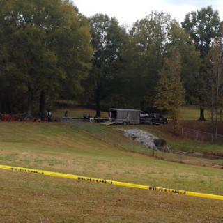 A view of a crime scene cordoned off with police tape, indicating an ongoing investigation.