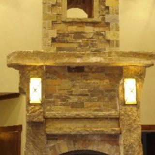 A stone fireplace with integrated lighting in a cozy interior setting.