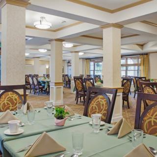 An elegantly decorated dining room with set tables and stylish chairs, ready for guests.