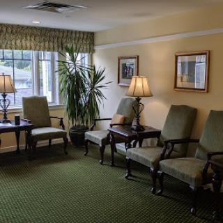 A cozy waiting area featuring comfortable seating, lamps, and a decorative plant.