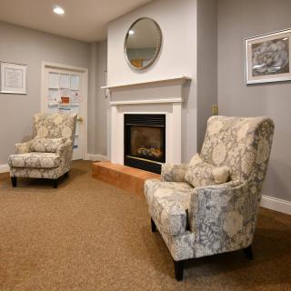 A cozy living room with patterned chairs and a fireplace.