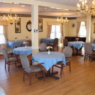 A well-decorated dining area featuring blue tablecloths and elegant chandeliers.