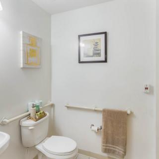 A modern minimalist bathroom with artwork and towel rack.