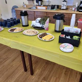 A table set up with various snacks and coffee for a buffet-style breakfast.