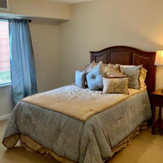 A cozy bedroom with a neatly made bed and soft lighting.