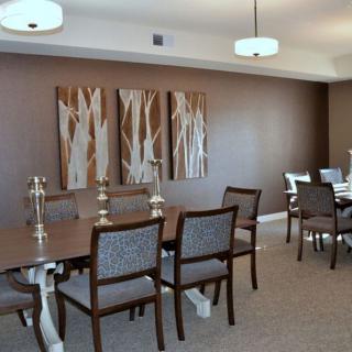 A modern dining room featuring a large wooden table, elegant chairs, and contemporary artwork on the walls.