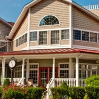 A charming two-story house with a welcoming porch and large windows.