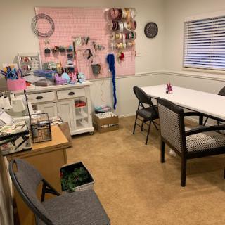 A cozy workspace designed for crafting, featuring organized supplies and ample seating.
