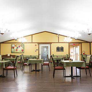 A well-lit dining area with neatly arranged tables and chairs.