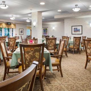 A spacious and elegantly decorated dining room with wooden chairs and tables.