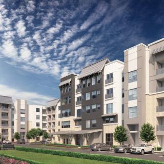Modern apartment complex under a vibrant blue sky.