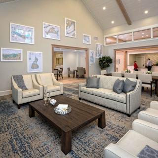 A modern living room with stylish sofas, a wooden coffee table, and framed artwork on the walls.