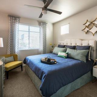 A modern bedroom with blue bedding and stylish decor.