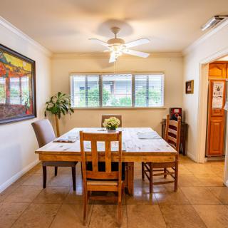 A cozy dining room with a wooden table, chairs, and artwork on the wall.