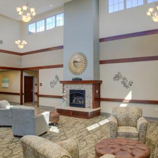 A modern lobby with comfortable seating and a central fireplace.