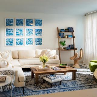 A stylish living room featuring a cozy white sofa, wooden coffee table, and wall-mounted artwork.