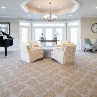 A bright and inviting living room featuring comfortable seating, a grand piano, and elegant decor.