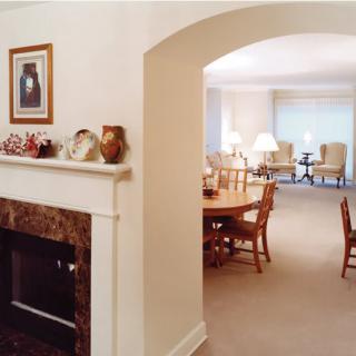 A cozy living and dining area featuring a fireplace, traditional furniture, and neutral tones.